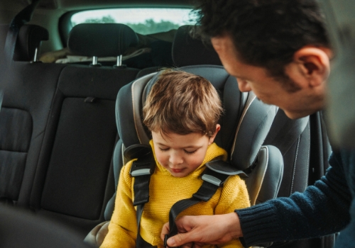 Father belts child into car seat