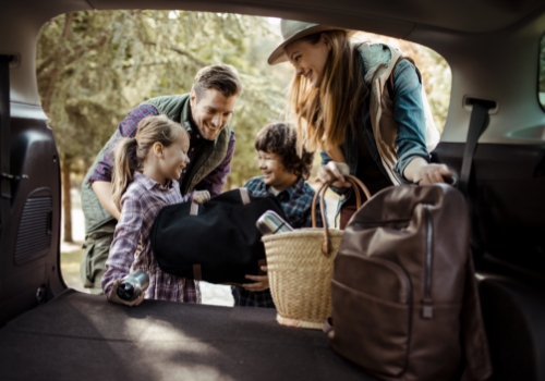 Family of four packing the boot of their car